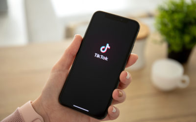 Woman holding iPhone X with streaming service media video TikTok
