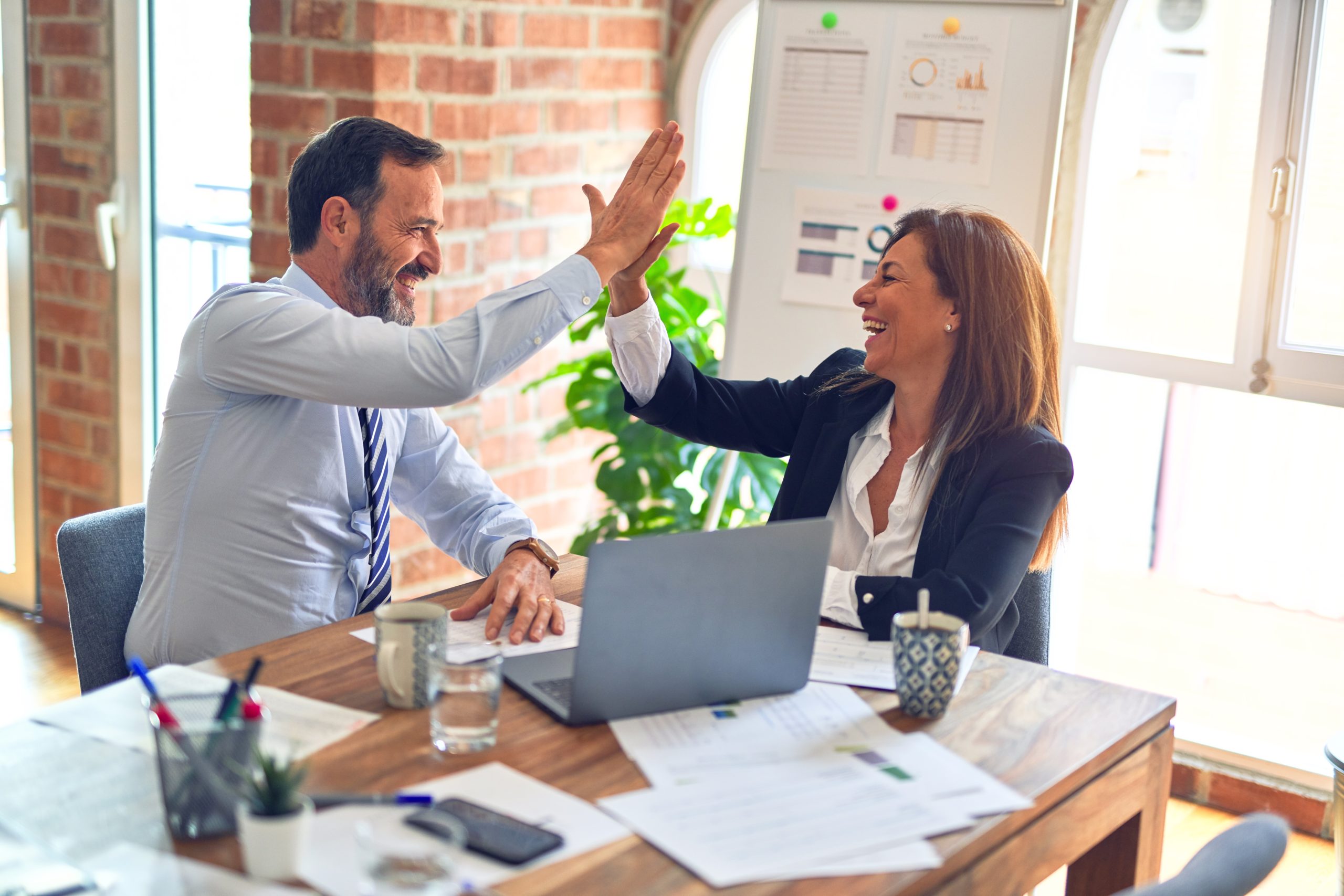 Two colleagues sharing a high-five after a personal meeting